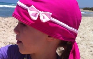 girl with pink and bow sun protection swimming cap