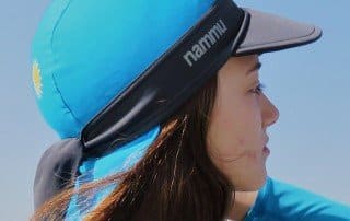 a girl on the beach wearing nammu swim caps with visor