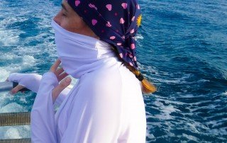 woman with sun protective turtleneck white swim shirt and swim cap