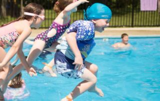 boy with cochlear implants hat jump into the pool