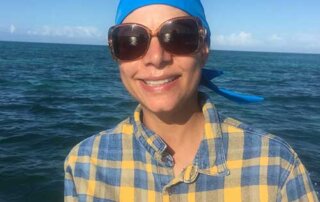 woman wearing blue nammu sun protective swim cap in the sea