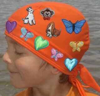 orange nammu sun protective swim cap decorated with iron patches