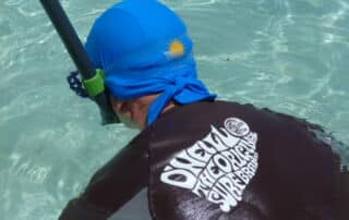 a man snorkeling with classic blue nammu sun protective swimming cap
