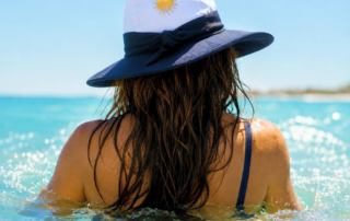 women in the sea waves wearing nammu 360 wide brim water and sun hat