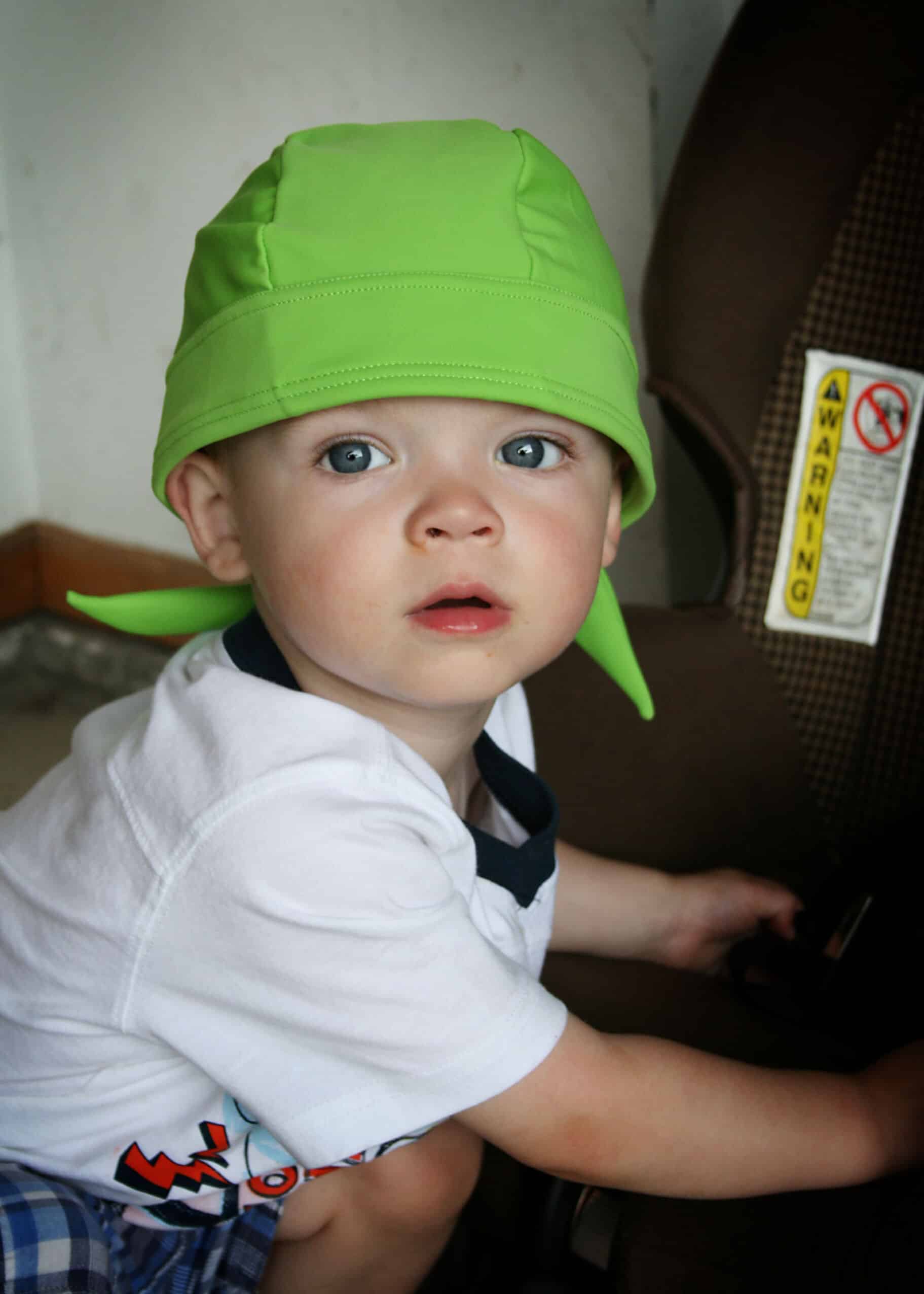 toddler wearing green nammu sun protection swimming hat